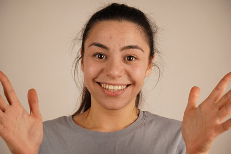 The arms are spread wide, expressing the emotion of surprise. This gesture conveys an immediate reaction to something unexpected. The open palms and raised posture enhance the feeling of surprise.の写真素材