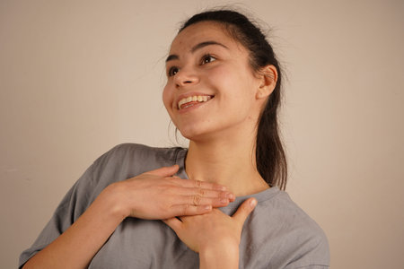 The hands lie gently on the chest, conveying surprise and joyful anticipation. The expression...