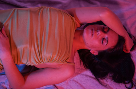 Young woman at home, she is relaxing and sleeping on the carpet.の写真素材