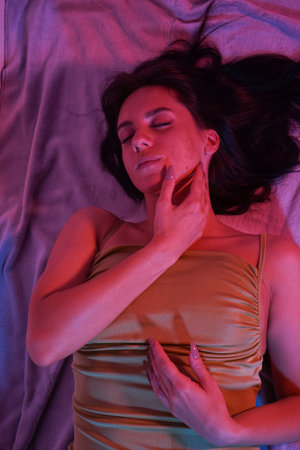 Close up portrait of a womans face with long dark straight hair lying on the floor.の写真素材