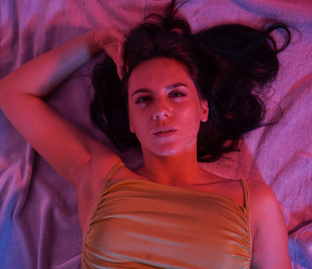 A young happy woman lying on the floor, she looks straight into the camera. Very close-up.の写真素材