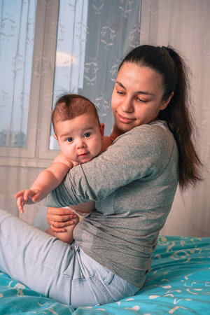 The mother strokes her son s back gently, her loving gaze fixeの写真素材