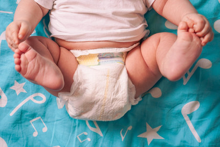 Cute little baby lying on bed, top view with space for text. Banner design.の写真素材