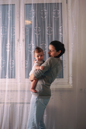 Pretty woman holding a newborn baby in her arms.の写真素材