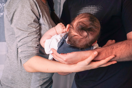 Mother and father smiling while holding their newborn baby - happy young parents with a newborn baby.の写真素材