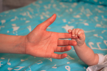 Tiny fingers curl around the parents finger, embodying the innocence and beauty of new life.