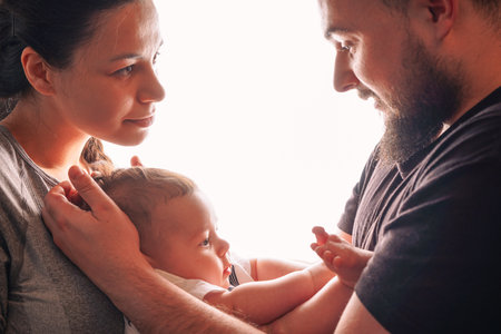 Happy young mother and father standing together in room at home,の写真素材