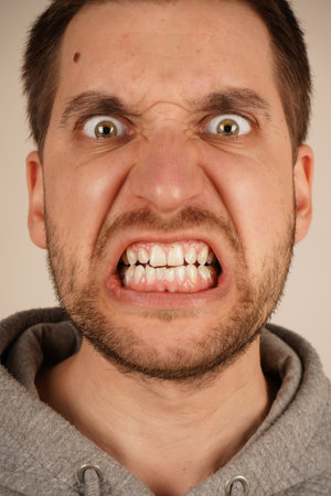 Portrait of frustrated angry man. Guy with dissatisfaction shows negative emotions isolated on grey background.の写真素材