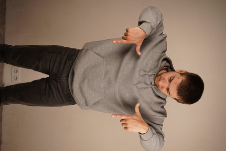 The image conveys clarity and purpose. Pointing down with both hands, the man focuses attention on a...
