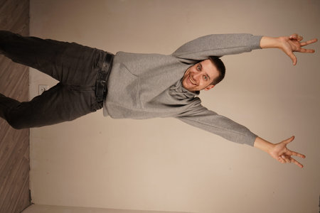 A man performs a dance with raised arms, highlighting three fingers on both hands. His lively...