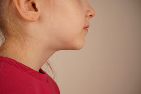 A detailed close-up of the girls chin, showcasing her facial expression. The focus is on the structure and features of her chin, reflecting the emotions conveyed through her expression.の写真素材