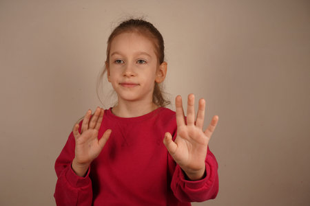 The girl seems to be distancing herself from something, evoking a sense of caution and emotional space. The teenage girl holds her hands in front of her.の写真素材