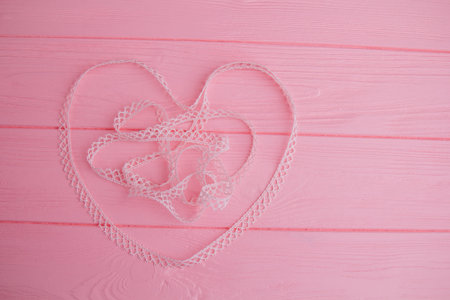 The heart is laid out on a pink table with an openwork ribbon. The laid out heart perfectly...
