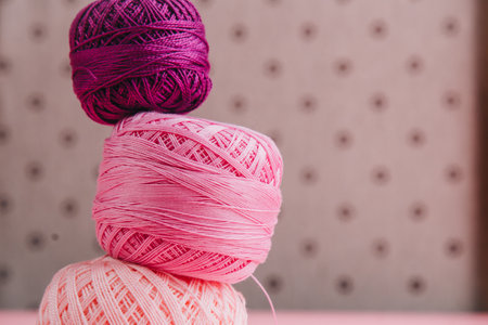 Elegant pink and purple threads stacked with delicate lace, perfect for crafting and decoration projects. Feminine and cozy setup.の写真素材