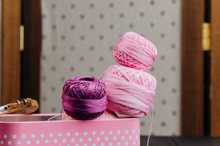 Neatly stored yarn and sewing products in a polka dot box on a black background, which evokes a sense of creativity and handicraft.の写真素材