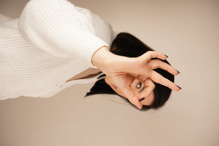 A woman makes an OK sign with her fingers. Her playful manner conveys a sense of fun and lightness....