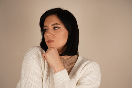 With hands layered, the woman emanates a sense of purpose and self-assurance. Her determined gaze reinforces her strong-willed attitude. A moment reflecting tenacity and inner strength.の写真素材