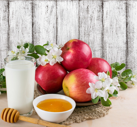Red apples with milk and honey, decorated apple flowers on the background wooden wall in the style Shabby Chicの写真素材