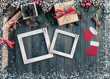Christmas background with photo frame, spruce, gift box, Santa Claus boots and scroll in vintage style on wooden shabby boards. Top view.の写真素材