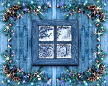 Christmas wooden windows decorated with New Year decor in rustic vintage style with light illumination, snow and spruce. Winter holidays concept.の写真素材