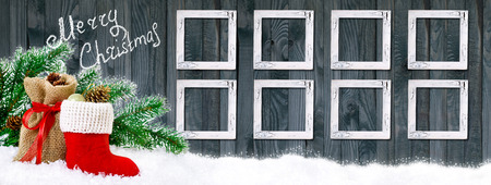 Santa boot and bag with gifts and cones on wooden wall background with vintage shabby photo frame. Christmas banner.の写真素材