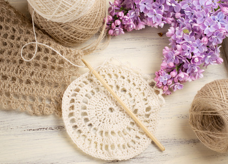 Yarn for crochet and knitted openwork napkins with lilac on shabby wooden boardの写真素材