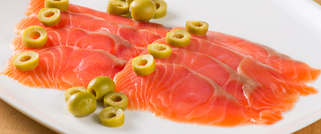 Sliced salted salmon served with oliveの写真素材