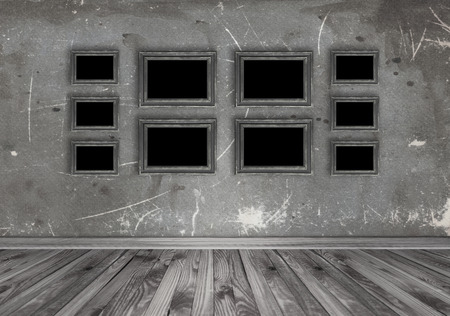 Home interior with set of empty photo frames on grungy wall background. Copy space.の写真素材