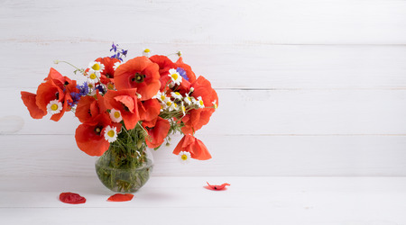 Poppies, cornflowers and daisy bouquet in vase on background of shabby wooden planks in provence style. Interior design.の写真素材