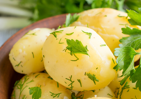 Young boiled potatoes with dill in the bowl, parsley and onions の写真素材