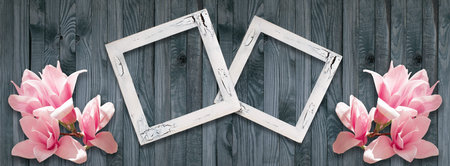 Spring background with photo frames and pink magnolia flowers on wall of shabby wooden planks.の写真素材