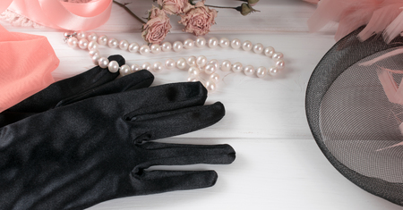 Women's retro accessories including velvet gloves and pearl necklace on wooden  tableの写真素材