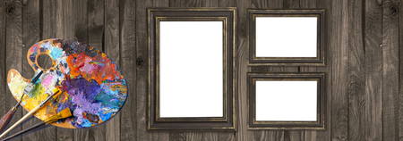 Palette for oil paints with brushes, palette knife and picture frames on shabby wooden background. Template for oil art master class advertising.の写真素材