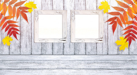 Autumn background with two photo frames and autumnal leaves on wooden boards in Shabby Chic style. Copy space. Empty place for for your decoration, text or advertising.の写真素材