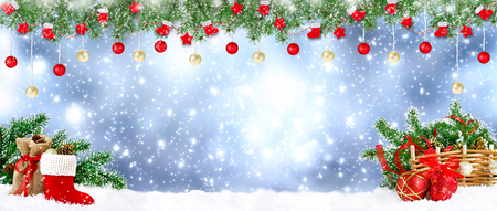 Christmas banner. Santa boot with spruce garland, balls, bag, gifts and cones on snowing background. New Year winter holidays concept. Empty place for photo or text. Copy space.の写真素材