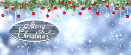 Christmas banner. Santa boots, gloves, stars and balls hanging on spruce garland and signboard on snowing background. New Year winter holidays concept. Empty place for photo or text. Copy space.の写真素材