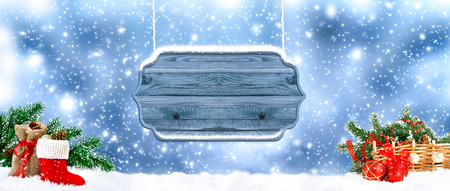 Christmas banner. Santa boot with signboard, balls, bag, gifts and cones on snowing background. New Year winter holidays concept. Empty space for your text or advertising.の写真素材