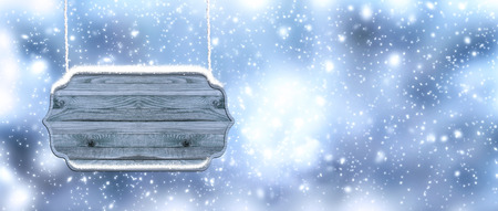Christmas banner with wooden signboard on snowing background. New Year winter holidays concept. Empty place for decoration, text or advertisingの写真素材