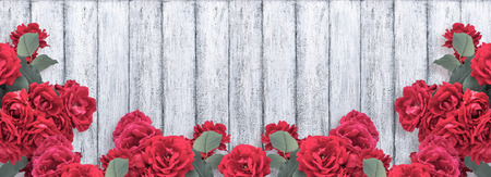Banner with red roses and place for your text on background of shabby wooden planks in rustic style. Top view. Flat design. Copy space.の写真素材