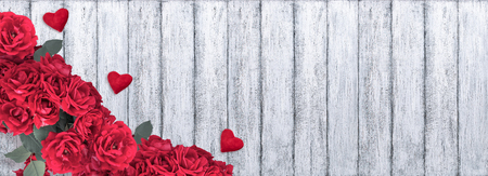 Banner with red roses, Valentine hearts and place for your text on background of shabby wooden planks in rustic style. Top view. Flat design. Copy space.の写真素材