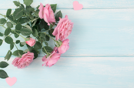 Top view of pink roses with paper hearts on background of shabby wooden planks and place for your textの写真素材