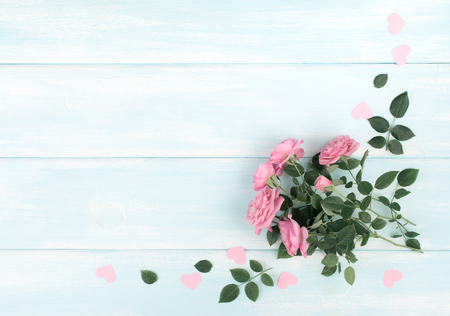 Top view of pink roses with paper hearts on background of shabby wooden planks and place for your textの写真素材