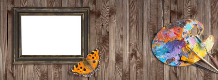 Palette for oil paints with brushes, palette knife and picture frames with butterfly on shabby wooden background. Template for oil art master class advertising.の写真素材
