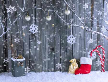 Christmas interior with decorative branches, Santa boot, gift bag and balls on wooden planks background. New Year winter composition.の写真素材