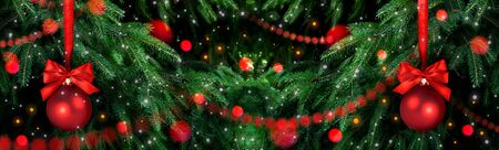 Christmas background with fir tree, two balls, glowing garland and snowfall. New Year winter holidays theme.の写真素材