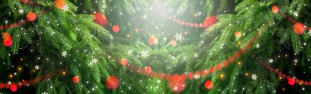 Christmas background with fir tree, glowing garland and snowfall. New Year winter holidays theme.の写真素材