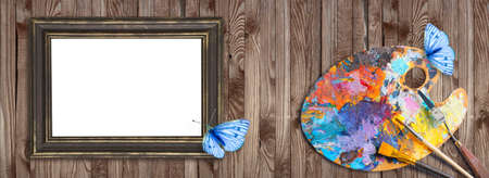 Palette for oil paints with brushes, palette knife and picture frames with butterfly on shabby wooden background for design shop artists. Template for oil art master class advertising.の写真素材