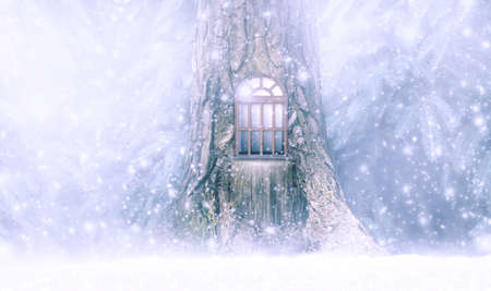 Christmas festive fabulous card with pine tree fairytale house, window, winter snow background, snowfall and snowflakes. Fantasy new year fairy tale landscape with snowy spruce fir tree forest.の写真素材