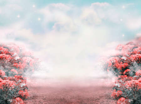 Fantasy summer photo background with roses flowers field and misty path leading to fairytale glade. Idyllic tranquil morning scene, road goes across hills, empty copy space. Toned in pastel colors.の写真素材