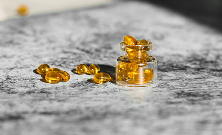 Cod liver capsules lined on decorative gray background.の写真素材